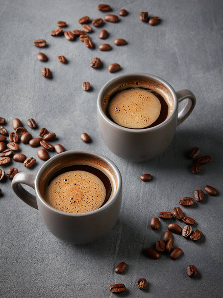 kaksi kuppia tuoretta kahvia harmaalla pohjalla
 - Valokuva, kuva