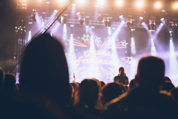 Luces de escenario y multitud de espectadores con las manos levantadas en un festival de música. Los fans disfrutando de las vibraciones de la fiesta
. - Foto, Imagen