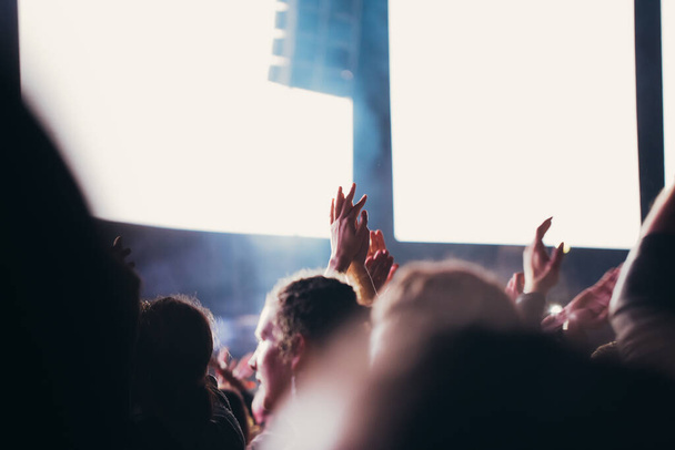Сценічні вогні та натовп аудиторії з піднятими руками на музичному фестивалі. Вболівальники насолоджуються вечіркою
. - Фото, зображення