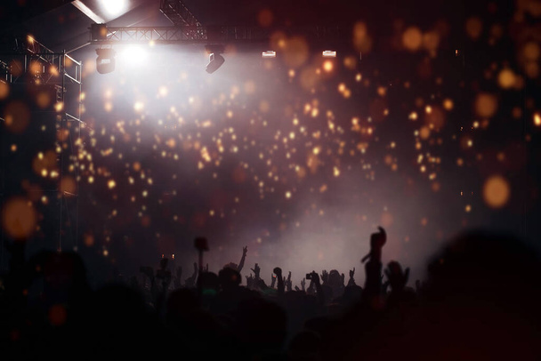 Jevištní světla a dav diváků s rukama zdviženýma na hudebním festivalu. Fanoušci si užívají párty vibrací. - Fotografie, Obrázek