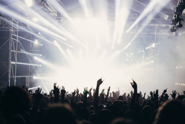 Сценические огни и толпа зрителей с поднятыми руками на музыкальном фестивале. Фанаты наслаждаются вечеринками
. - Фото, изображение