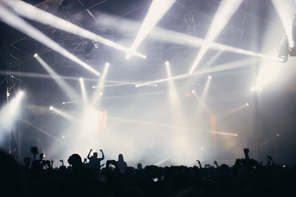 Lumières de scène et foule avec les mains levées lors d'un festival de musique. Les fans apprécient les vibrations de la fête
. - Photo, image