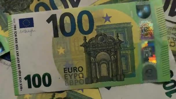Bovenaanzicht van de stapel nieuwe 100 eurobankbiljetten die in 2019 zijn uitgegeven, verspreid over het oppervlak, draaiend in een cirkel met de klok mee.Concept van rijkdom, overvloed en fortuin. Zachte focus.Eindeloze lussen video - Video