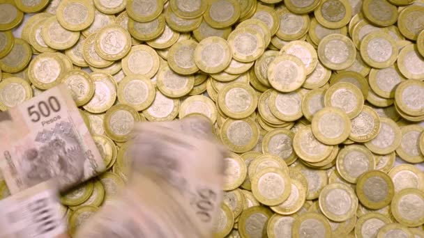 Un mucchio di banconote da 500 sta piovendo su un mucchio di monete messicane
 - Filmati, video
