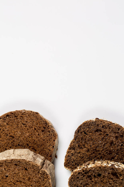 Pão preto e branco fresco saboroso com trigo e farinha em um fundo branco
 - Foto, Imagem