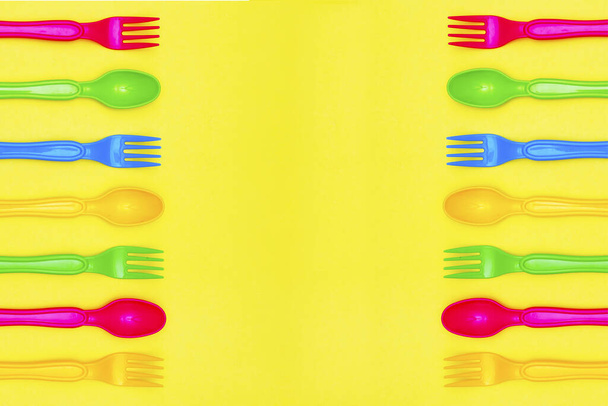 Vista superior de la cuchara colorida y el elemento de horquilla en el diseño de color amarillo table.flat lay
. - Foto, Imagen