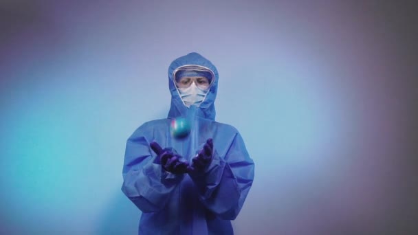 Virus. A doctor in a protective medical suit against the virus throws a ball in the form of a planet of the earth. - Filmagem, Vídeo