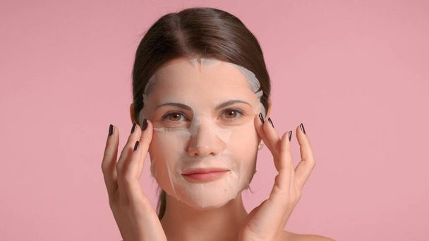 30s brunette nainen lähikuva muotokuva osoittaa lakana naamio. Itsehoidon käsite
 - Valokuva, kuva