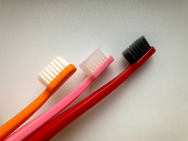 three multi-colored toothbrushes on a white background - Foto, Bild
