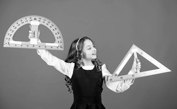 Smart and clever concept. Girl with big ruler. School student study geometry. Kid school uniform hold ruler. School education concept. Sizing and measuring. Learn mathematics. Theorems and axioms - Foto, imagen