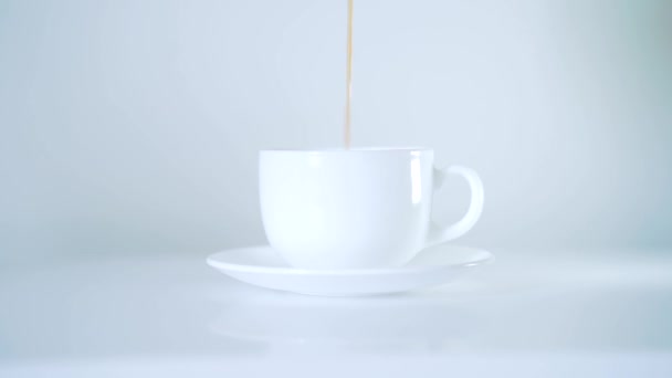 pour coffee into a white cup. white background. side view - Metraje, vídeo