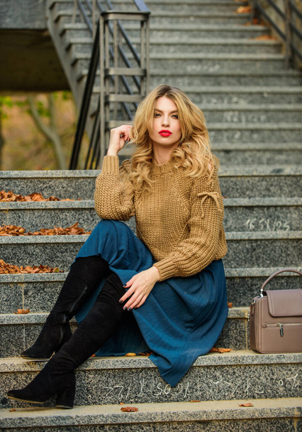 Wearable trends. Layer oversize knit over girly skirt. Fall outfit formula. Style Sweater and Skirt Combo for Fall. Woman gorgeous hairstyle sit on stairs outdoors. Warm autumn. Fall fashion trend - Foto, Bild
