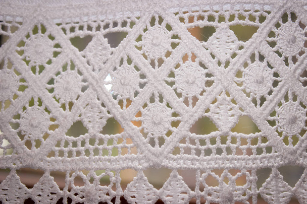 Egy kézzel készített fehér Macrame függöny geometrikus mintával Windóban. - Fotó, kép