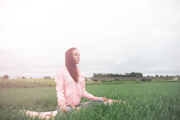 A menina no ioga ao ar livre em um campo - Foto, Imagem