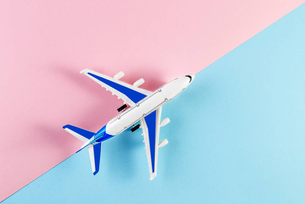 Model plane, airplane on a pink and blue background. Summer travel concept - Foto, imagen