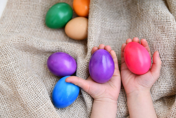 children hands holding easter eggs on burlap background - Zdjęcie, obraz