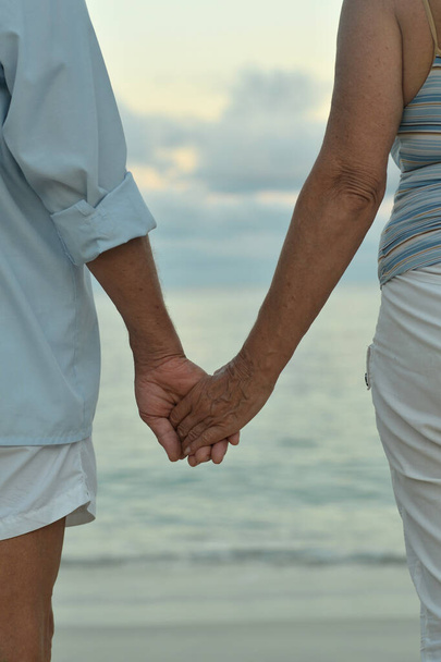 Gelukkig ouder stel hand in hand op tropisch strand - Foto, afbeelding