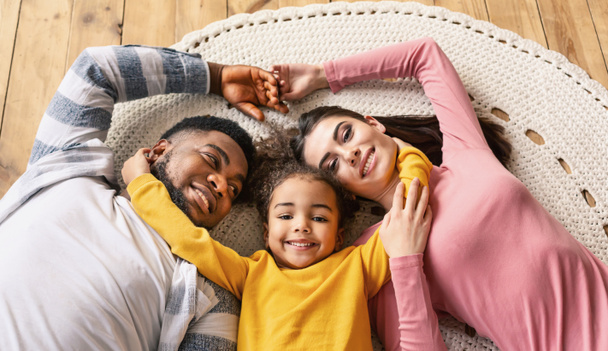 Lächelnde multirassische Familie liegt auf dem Boden - Foto, Bild