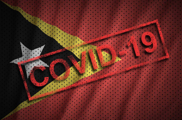 Itä-Timorin lippu ja punainen Covid-19 leima. Coronavirus 2019-nCov-taudinpurkauksen käsite
 - Valokuva, kuva