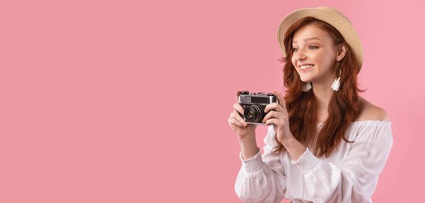 Glückliches Fotografenmädchen, das Fotos mit Fotokamera, rosa Hintergrund macht - Foto, Bild