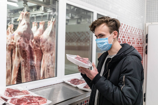 Hombre joven que usa máscara médica desechable comprando en el supermercado durante el brote de neumonía por coronavirus. Protección y prevención de medidas durante el tiempo de epidemia. Covid-19 persona
 - Foto, imagen