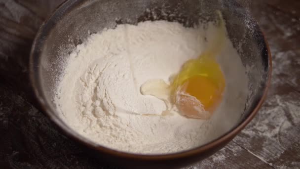 Plan au ralenti des chutes d'œufs sur un bol avec de la farine
. - Séquence, vidéo