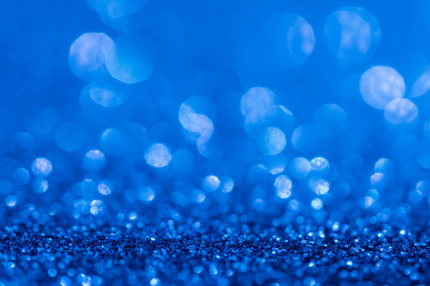 Glitter, sparkle defocused blurred blue background with bokeh lights - 写真・画像