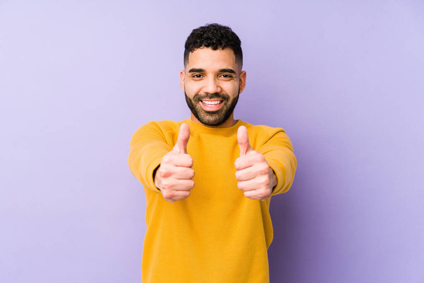 Young mixed race arabic man isolated with thumbs ups, cheers about something, support and respect concept. - Photo, Image