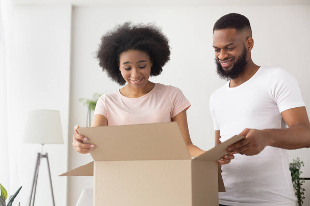 Glad african american millennial couple open box - Photo, Image