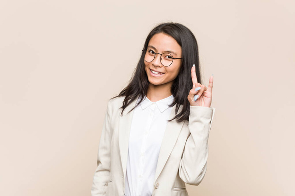Young business chinese woman showing a horns gesture as a revolution concept. - Photo, Image
