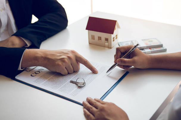 Novos compradores de casa estão assinando um contrato de compra de casa na mesa do agente. - Foto, Imagem