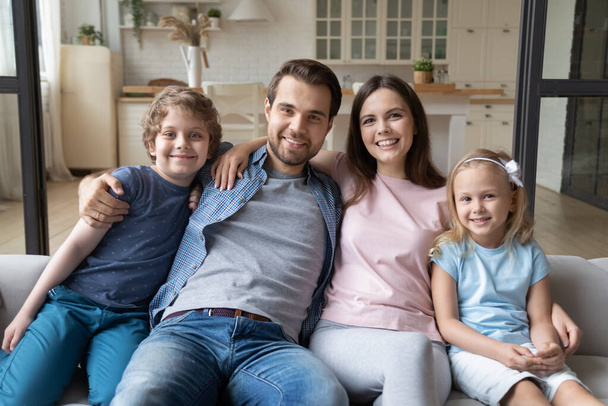 Portret van een gelukkig gezin met kinderen die thuis ontspannen - Foto, afbeelding