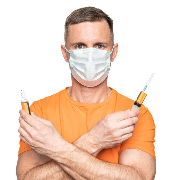 Healthcare and medicine concept.Young man in mask holding syringe and ampoule over white background - Foto, imagen