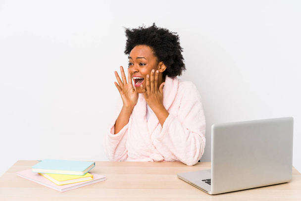 Afro-Amerikaanse vrouw van middelbare leeftijd die thuis werkt schreeuwt luid, houdt ogen open en handen gespannen. - Foto, afbeelding
