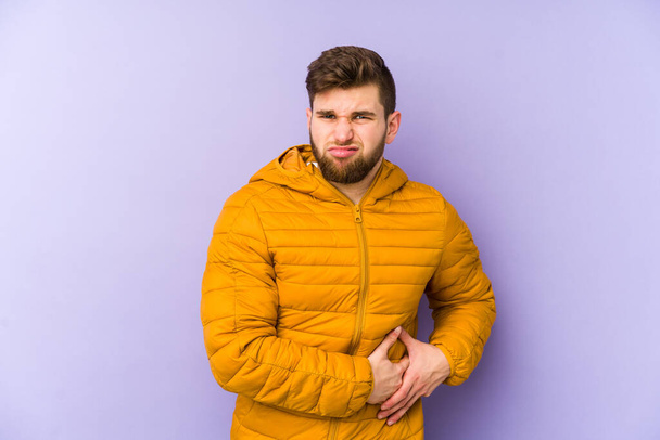 Jongeman geïsoleerd op paarse achtergrond met leverpijn, buikpijn. - Foto, afbeelding