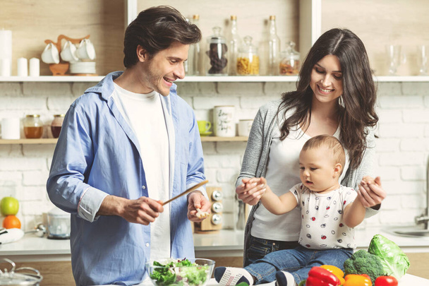 Young family cooking healthy lunch together at kitchen - Photo, Image