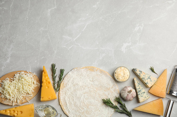 Flat lay composition with dough and fresh ingredients on grey marble table, space for text. Pizza recipe - Fotoğraf, Görsel