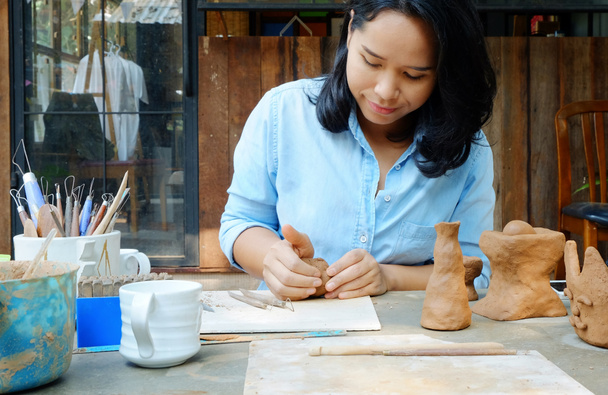 Asiatin formt handgefertigten Cray im Atelier, Hobby- und Lifestyle-Arbeitskonzept - Foto, Bild