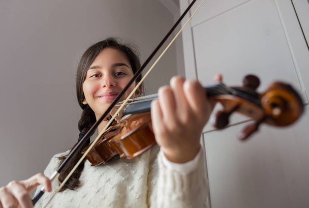 Fiatal diák mosolygós gyakorlat hegedű otthon, alulról nézve - Fotó, kép