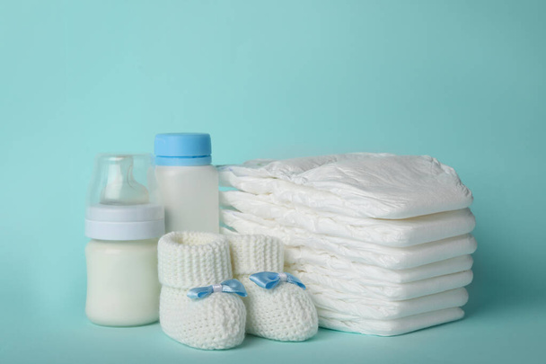 Diapers and baby accessories on light blue background - Fotoğraf, Görsel