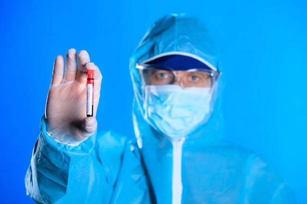 Ιός του Coronavirus έννοια ανάλυση αίματος. Δοκιμαστικός σωλήνας με δείγμα αίματος στο χέρι του γιατρού, κοντινή προβολή. - Φωτογραφία, εικόνα