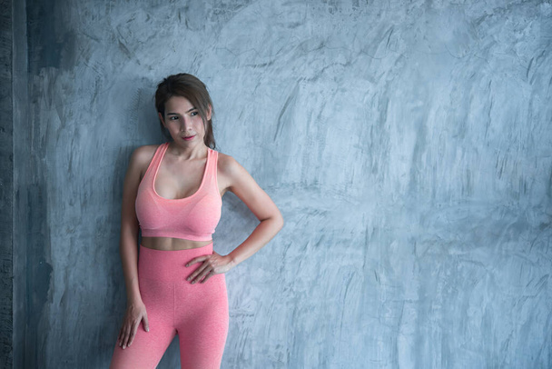 Close up asian beautiful sport girl on wall of gym,Thailand love health,Slim woman workout concept - 写真・画像