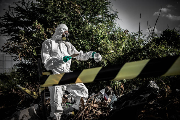アジアの科学者は、危険なゾーンで働く化学的保護スーツチェック危険化学作業を身に着けている - 写真・画像