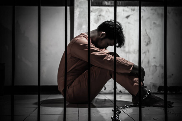Asian man desperate at the iron prison, prisoner concept - Foto, afbeelding