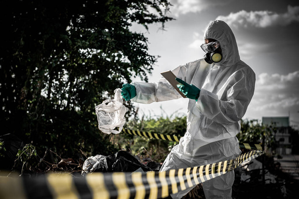 Азіатський вчений носить хімічний захисний костюм, перевіряючи небезпеку хімічної роботи в небезпечній зоні. - Фото, зображення