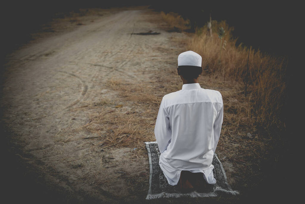 Young asian muslim man praying during sunset, Ramadan festival concept - Photo, Image