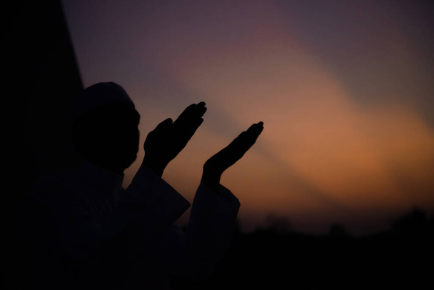 Silueta mladého asijského muslima modlícího se při západu slunce, koncepce Ramadan festivalu - Fotografie, Obrázek