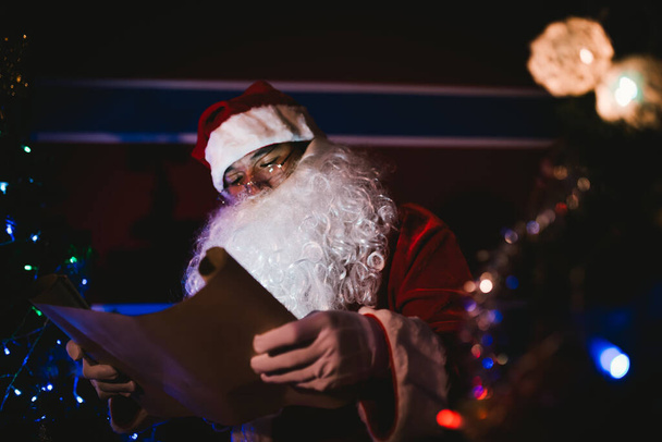 Portrait of santa clause read paper and checking list name for send gift to children - Foto, Imagem
