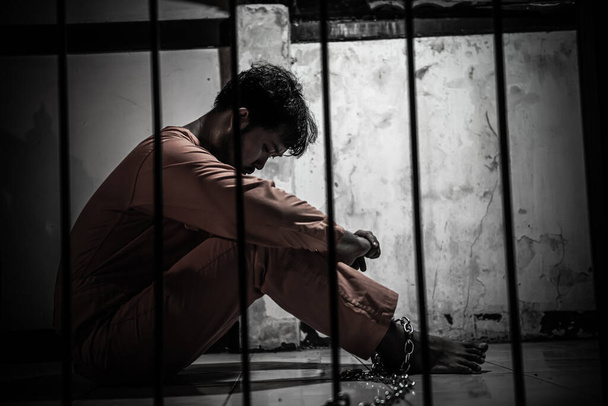 Asiatischer Mann verzweifelt am eisernen Gefängnis, Häftlingskonzept - Foto, Bild