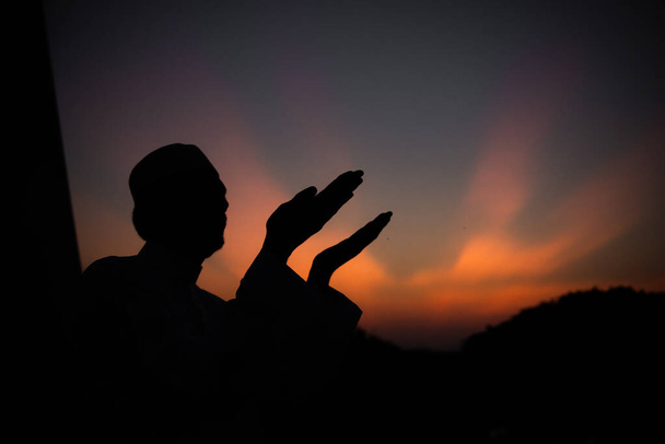 Silhouette Young asian muslim man praying on sunset, Ramadan festival concept - Photo, Image